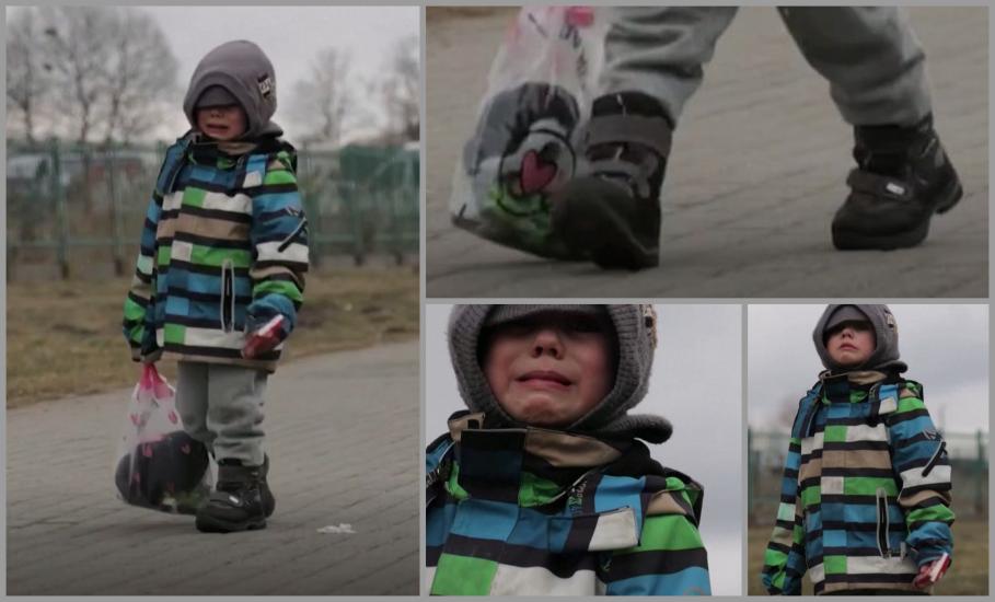 Un băieţel din Ucraina plânge şi trage după el o jucărie de pluş, în timp ce trece singur graniţa spre Polonia