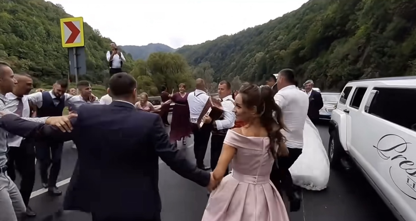 VIDEO. Petrecere pe Valea Oltului. Blocați în trafic, mai mulți nuntași au încins o sârbă printre mașini